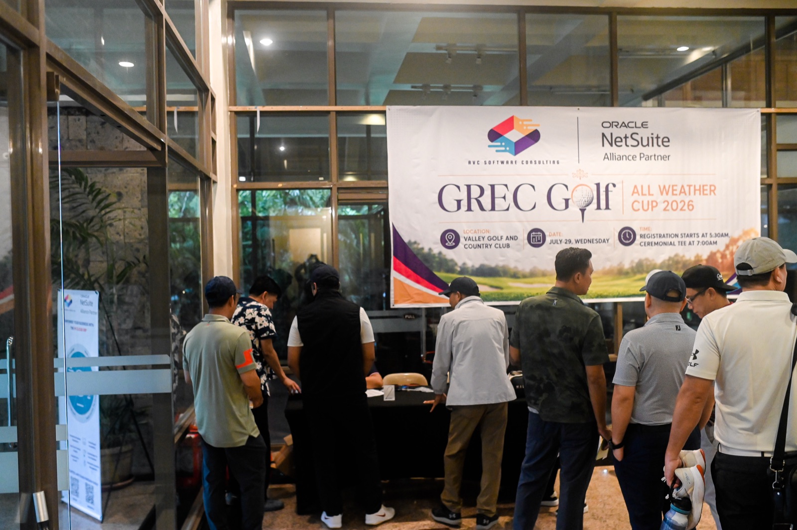 Golfers checking in at registration beneath the GREC Golf All Weather Cup 2026 banner