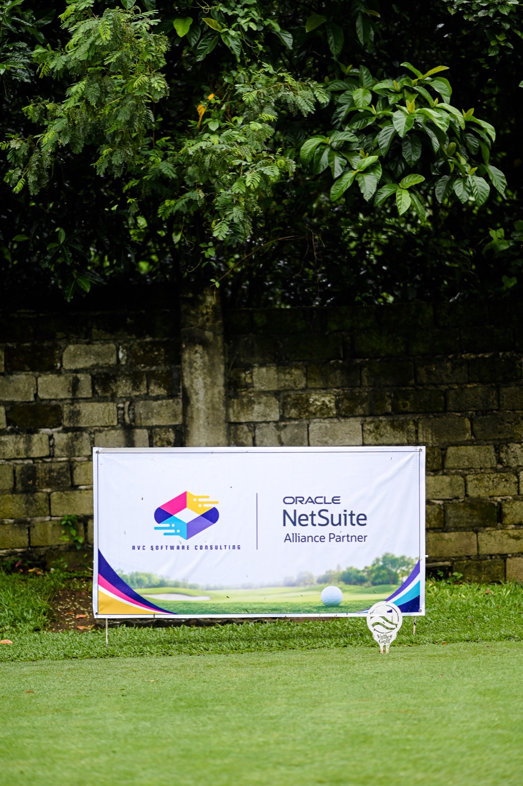 AVC Software Consulting and Oracle NetSuite sponsor banner along the course wall