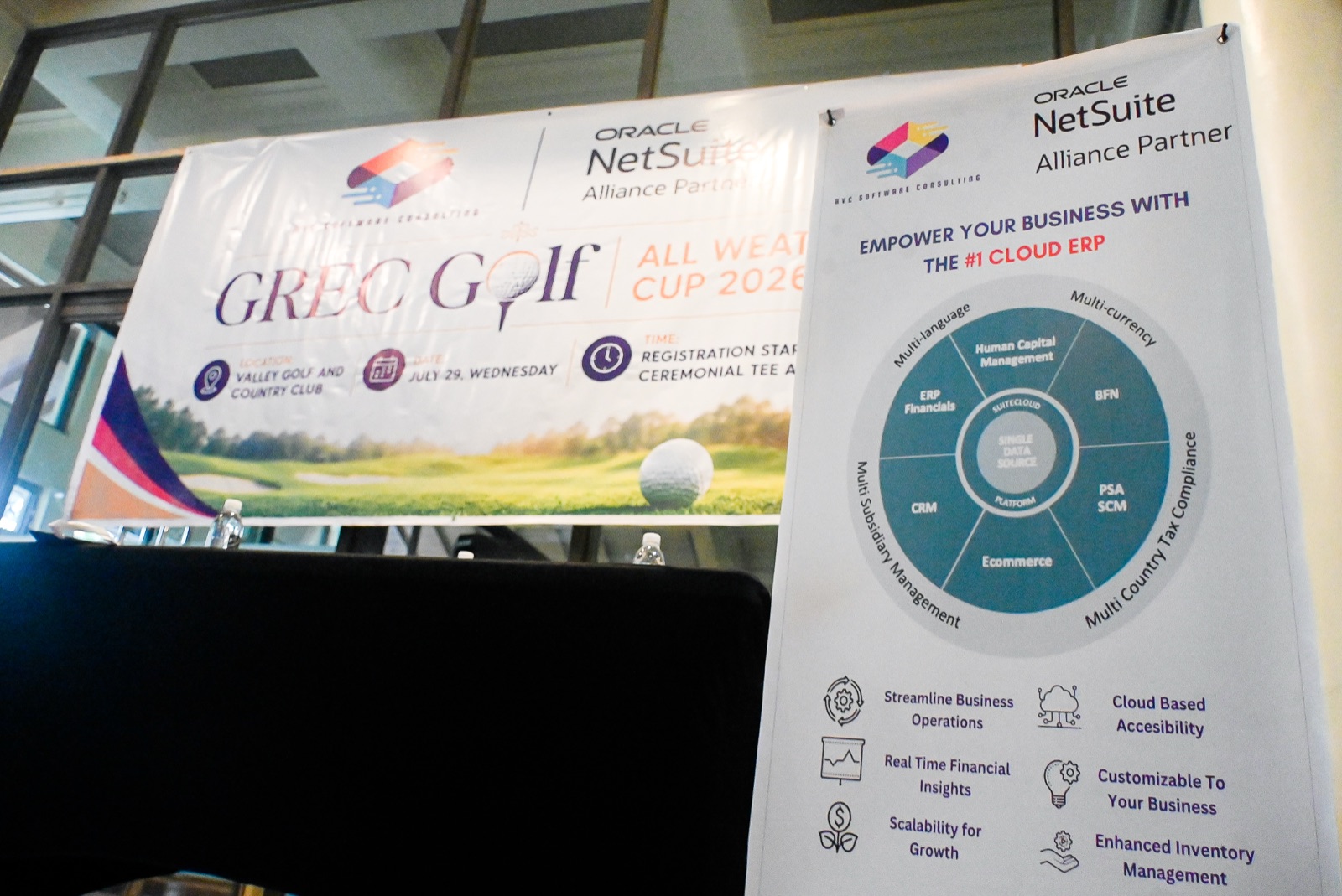 GREC Golf All Weather Cup 2026 and Oracle NetSuite banners on stage